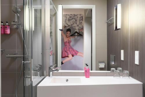 Eine Frau in einem Bild von sich in einem Badezimmerspiegel in der Unterkunft Moxy York in York