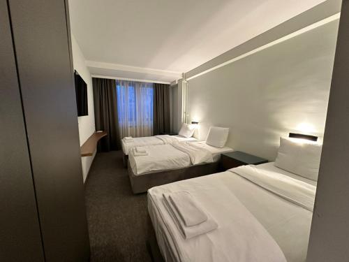 um quarto de hotel com duas camas e uma janela em Hotel Pljevlja em Pljevlja