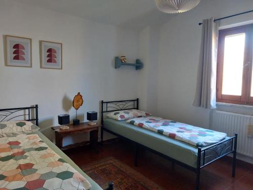 a bedroom with two beds and a window at Casa Cossi in Maissana