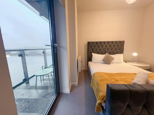 Riverside Retreat with Spectacular Views Glasgow في غلاسكو: غرفة نوم بسرير ونافذة كبيرة