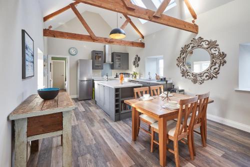 a kitchen with a wooden table and wooden chairs at Host & Stay - Fenwick Village Hall in Fenwick