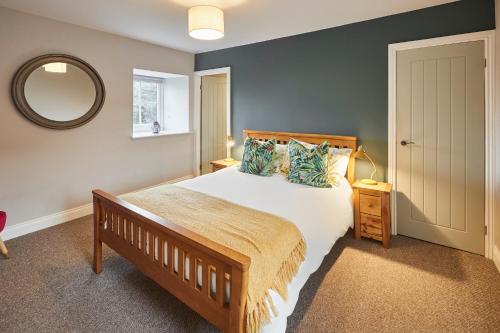a bedroom with a large bed and a mirror at Host & Stay - Fenwick Village Hall in Fenwick
