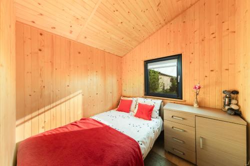 Un dormitorio con una cama en una habitación de madera. en Malinowe Zacisze, en Rusinowo