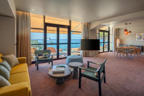 un salon avec un canapé, des chaises et une télévision dans l'établissement Résidence Les Embruns & Spa, à Cannes