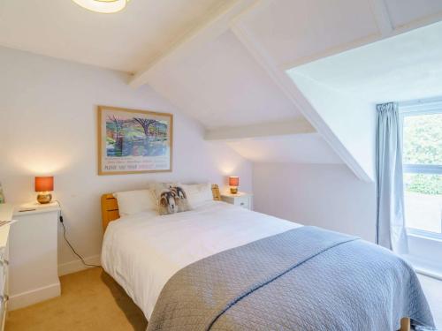 a bedroom with a white bed and a window at 3 Bed in Bassenthwaite 84024 in Bassenthwaite