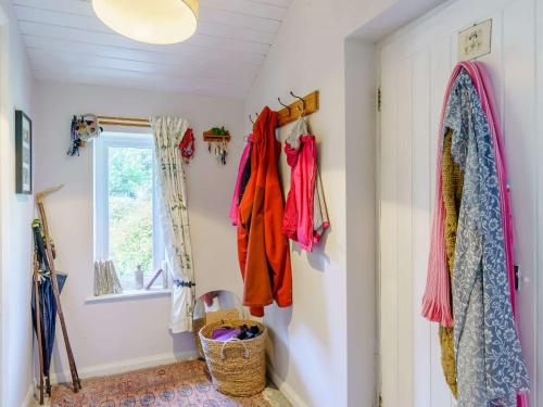 a hallway with clothes hanging on the wall and a window at 3 Bed in Bassenthwaite 84024 in Bassenthwaite