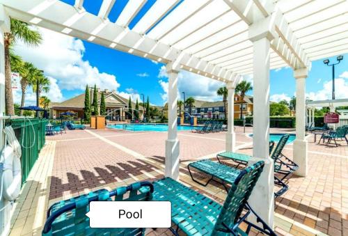 a white pergola with two benches and a pool at Your home 5 * near Disney in Kissimmee