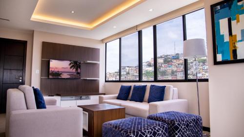 sala de estar con sofá, sillas y ventanas en Suite 7 Bellini IV, Puerto Santa Ana, Guayaquil, en Guayaquil