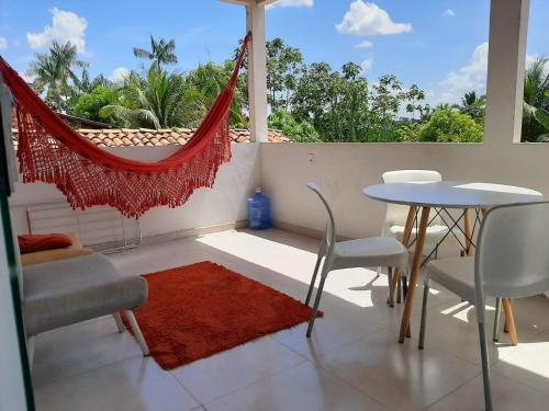 uma varanda com uma mesa, cadeiras e uma rede de descanso em Casa no Centro (Orla de Marabá) em Marabá