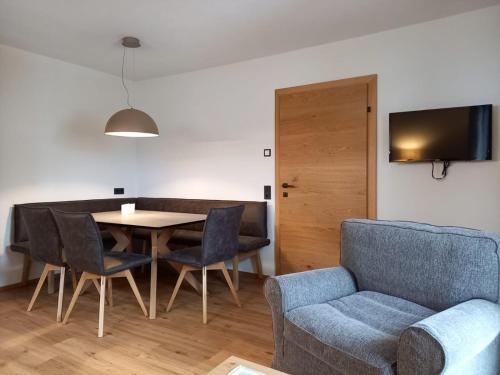 a living room with a table and chairs and a couch at Gästehaus Toferer in Grossarl