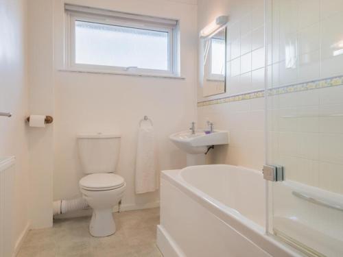 Baño blanco con aseo y lavamanos en 2 Bed in Keswick SZ008, en Keswick
