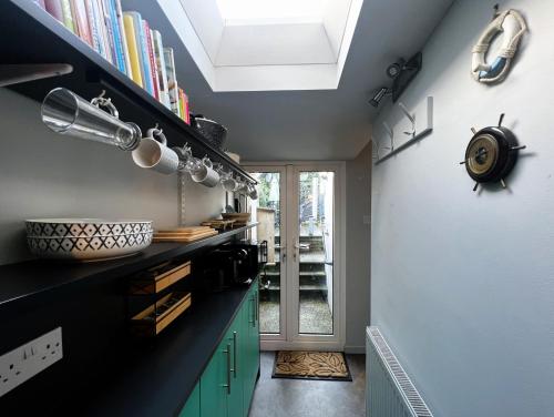 a kitchen with green cabinets and a skylight at Ivy Cottage in Brading