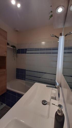 a bathroom with a white sink and a bath tub at Agréable villa à 3km de la mer in La Garde