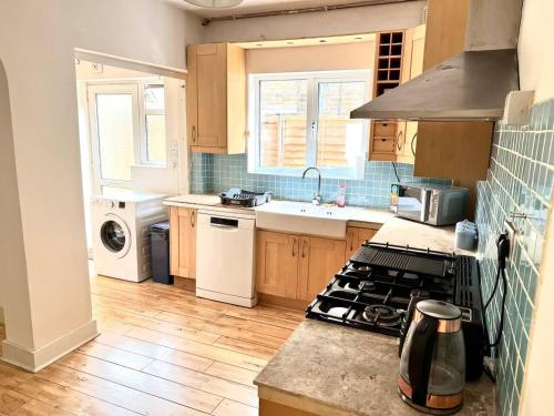 a kitchen with a stove and a counter top at Inviting 4-Bed House near Heathrow with fireplace in Egham