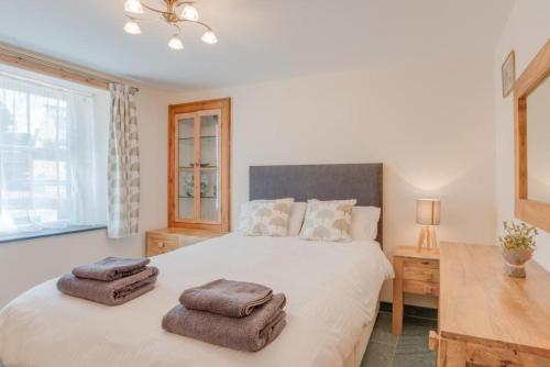 a bedroom with a large white bed with towels on it at 2 Bed in Ravenglass SZ409 in Ravenglass