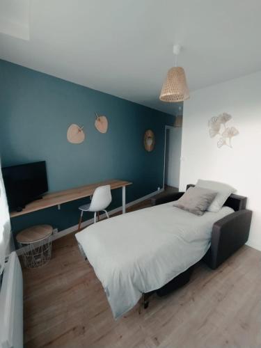 een slaapkamer met een groot bed en een bureau bij O'ZEN - studio calme et lumineux avec jardin in Sablé-sur-Sarthe