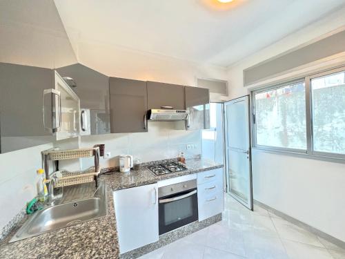 a kitchen with a sink and a stove top oven at Tanger SABOR Central Aparts Fibre -ONLY FAMILY in Tangier