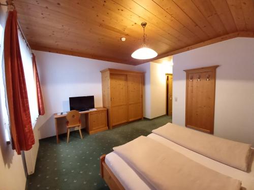 a bedroom with two beds and a desk with a computer at Gästehaus Toferer in Grossarl