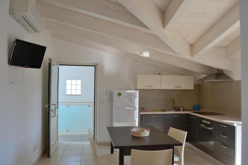 a kitchen with a table and chairs and a refrigerator at Appartamenti Vacanza in Roseto degli Abruzzi