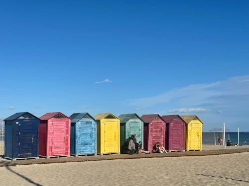 a row of colorful beach huts on the beach at Modern apartment directly on the beach with WiFi and air conditioning in El Campello