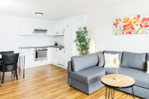a living room with a couch and a table at HEIMATEL - Suiten, Apartments und Studios in Scheidegg