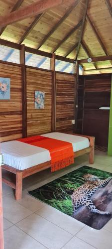 two beds in a room with a rug on the floor at La Joviseña in Nuquí