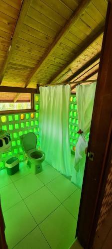 Habitación verde con aseo en una casa en La Joviseña, en Nuquí