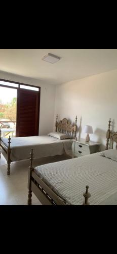 a bedroom with two beds and a window at bangalô Lucena in Lucena