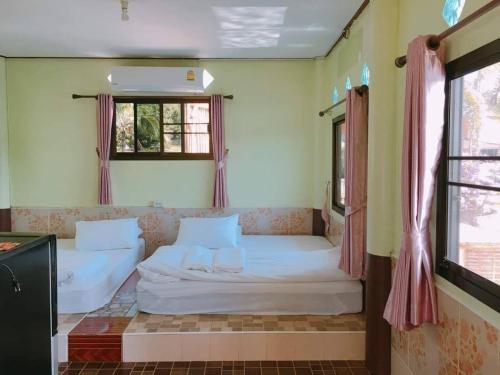 a bedroom with two beds and two windows at Chattong resort in Trat