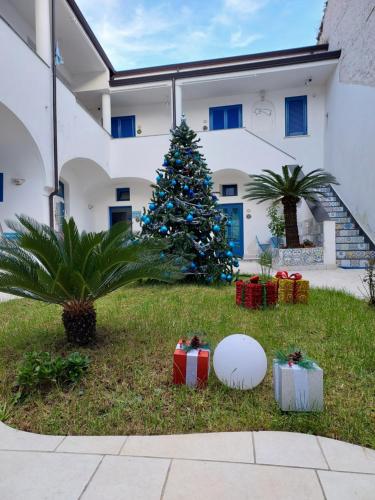 ein Weihnachtsbaum vor einem Gebäude mit Geschenken in der Unterkunft Suite FURORE in Aversa