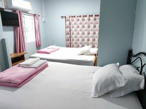 two beds in a hotel room with white sheets at Chattong resort in Trat