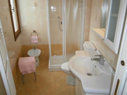 y baño con lavabo, ducha y aseo. en President Frontemare - Agenzia Cocal, en Caorle