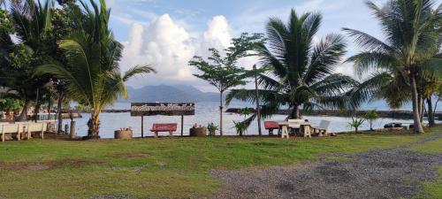 a beach with palm trees and a body of water at Chattong resort in Trat