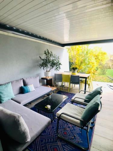 d'une terrasse avec un canapé, des chaises et une table. dans l'établissement Maison climatisée aux portes de Paris, à Suresnes