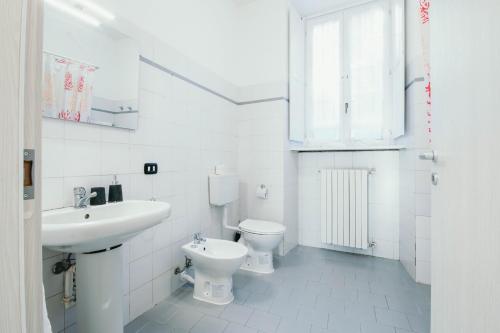 a white bathroom with a sink and a toilet at Bigattera trilocali - Affitti Brevi Italia in Varese