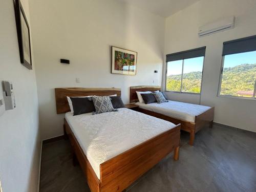1 dormitorio con 2 camas y ventana grande en Casa Abundia, en Carrillo