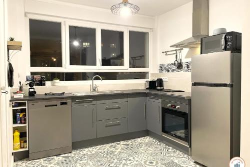 une cuisine avec un évier et un réfrigérateur dans l'établissement La Loggia - Superbe T3 - Confort - Hypercentre, à Caen