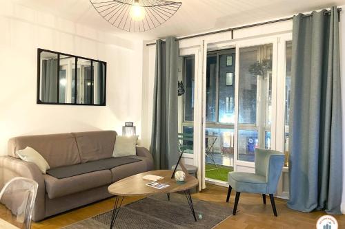 un salon avec un canapé et une table dans l'établissement La Loggia - Superbe T3 - Confort - Hypercentre, à Caen