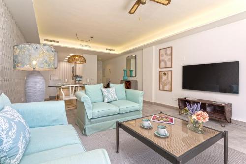 un soggiorno con due sedie blu e un tavolo di Genteel Home Infinity a Estepona