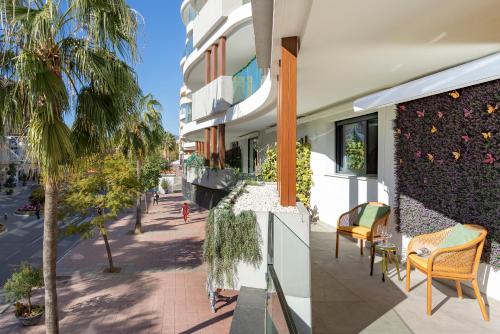 un balcone di un edificio con sedie e una palma di Genteel Home Infinity a Estepona