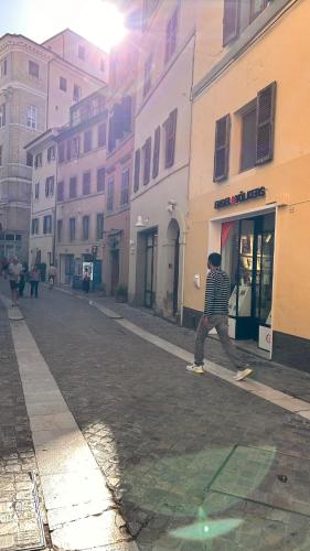 a man walking down a street in a city at Ankon Apartments Palazzo Mazzini in Ancona