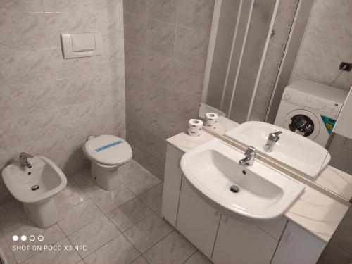 a white bathroom with a toilet and a sink at Mono Rosburgo 1 in Roseto degli Abruzzi