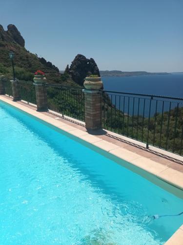 Ein Swimmingpool mit dem Meer im Hintergrund in der Unterkunft Il Miraggio Tanca Piras in Nebida