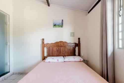 - un lit avec une tête de lit en bois dans l'établissement Suite Vista Panorâmica, à Betim