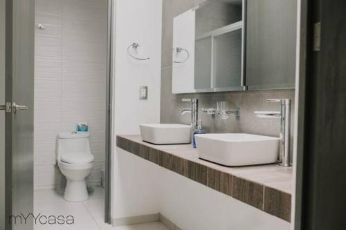 a bathroom with two sinks and a toilet at Spectacular House w/ Pool & Amazing Location in Trojes de Alonso