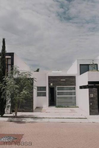 a white house with its door open on a street at Spectacular House w/ Pool & Amazing Location in Trojes de Alonso