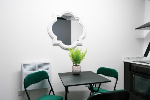 a table with chairs and a mirror on a wall at Credit Corner in Brierley Hill