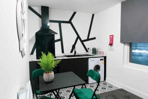 lavandería con mesa y sillas verdes en Credit Corner, en Brierley Hill