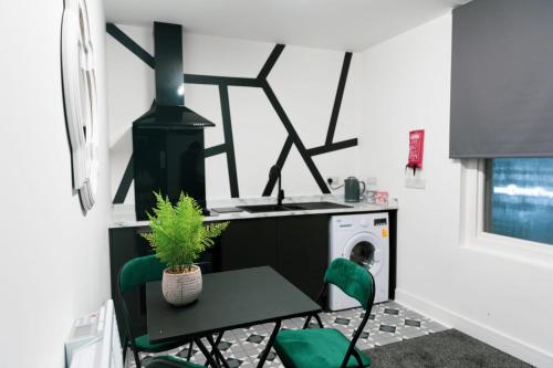 uma lavandaria com uma mesa e cadeiras verdes em Ledger Loft em Brierley Hill