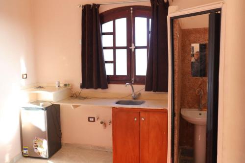 een kleine badkamer met een wastafel en een raam bij Calm moon nights hostel in Al Aqālitah